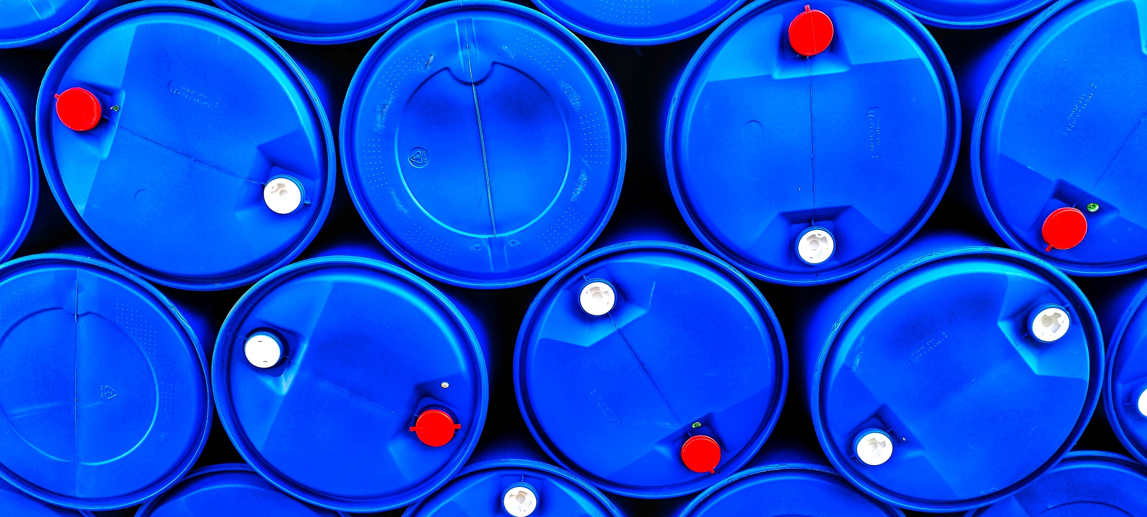 Close up of blue plastic drums stacked and placed in outdoor storage area